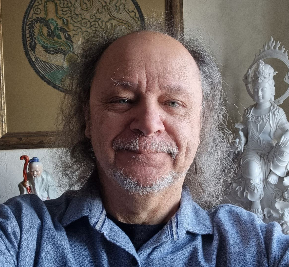 male face with long and curly hair and beard